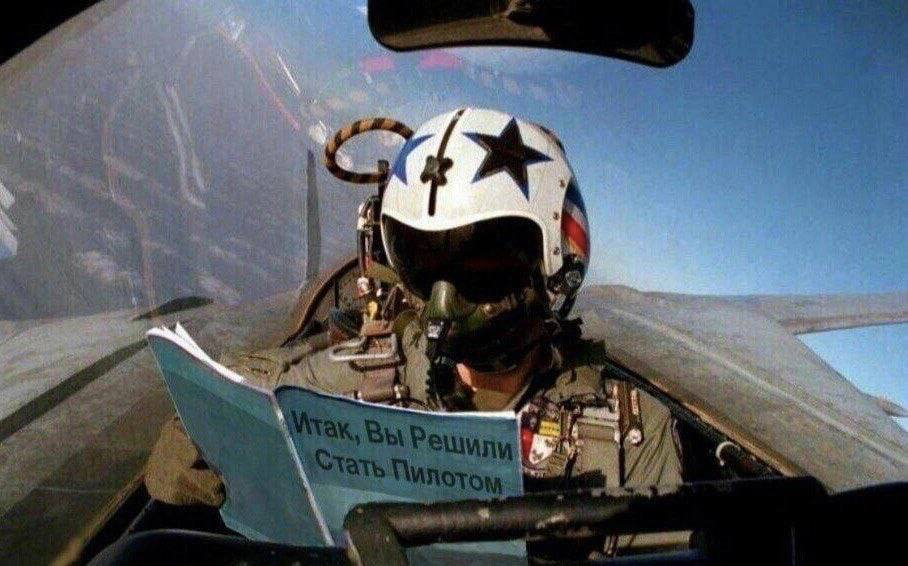 Пилот, читающий инструкцию об управлении самолётом во время полёта